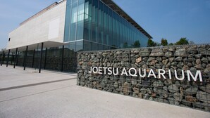 A modern building with a glass facade and a stone wall with the text "JOETSU AQUARIUM". - APA Hotel Joetsu Myoko Ekimae (Joetsu)