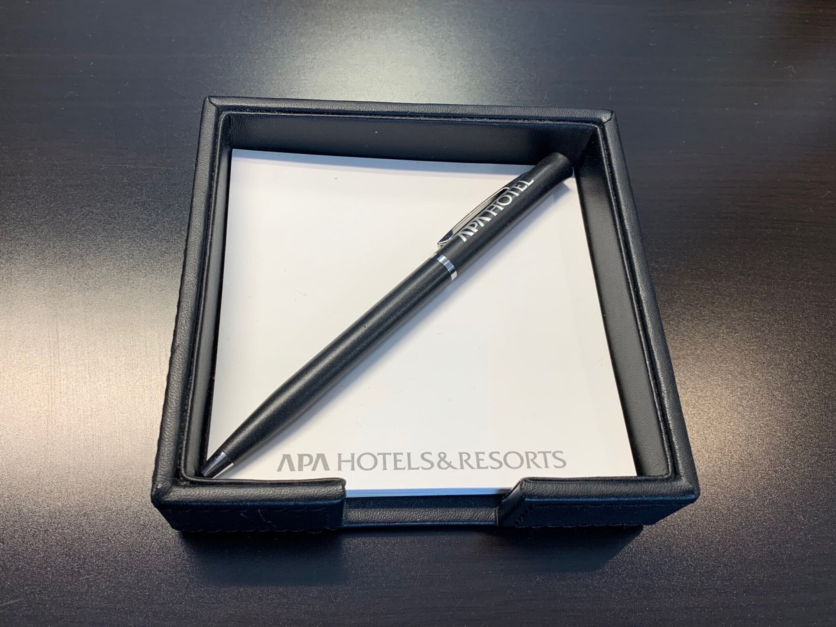 Un stylo noir dans une boîte noire, avec le texte « APA HOTELS&RESORTS » inscrit à l’intérieur.