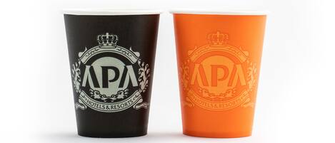 Two cups with the APA Hotels & Resorts logo, one black and one orange.