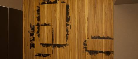 A wall with a wooden panel design and a small white device on a black surface.