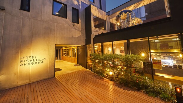 Exterior moderno de un hotel con terraza de madera, entrada de vidrio y un letrero que dice "HOTEL RISVEGLIO AKASAKA".
