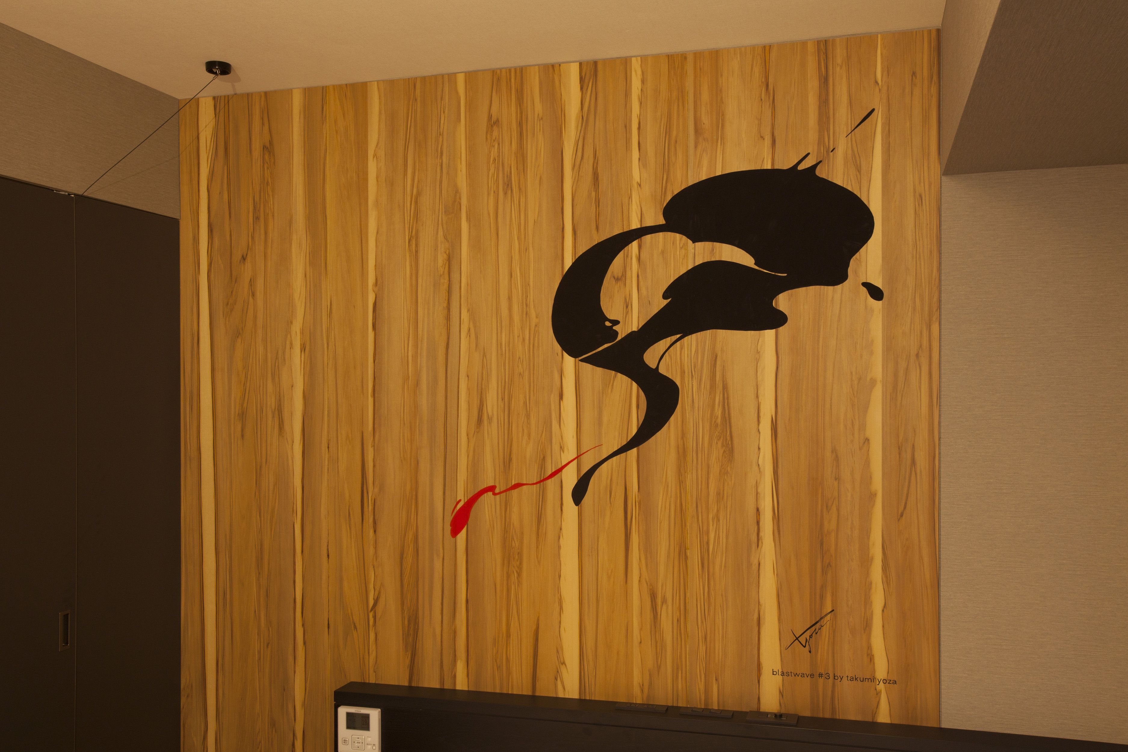 Eine Holzwand mit einem schwarzen und roten abstrakten Muster.