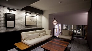 Una sala de estar moderna con una pared de ladrillo blanco, un sofá, una mesa de centro y una silla.