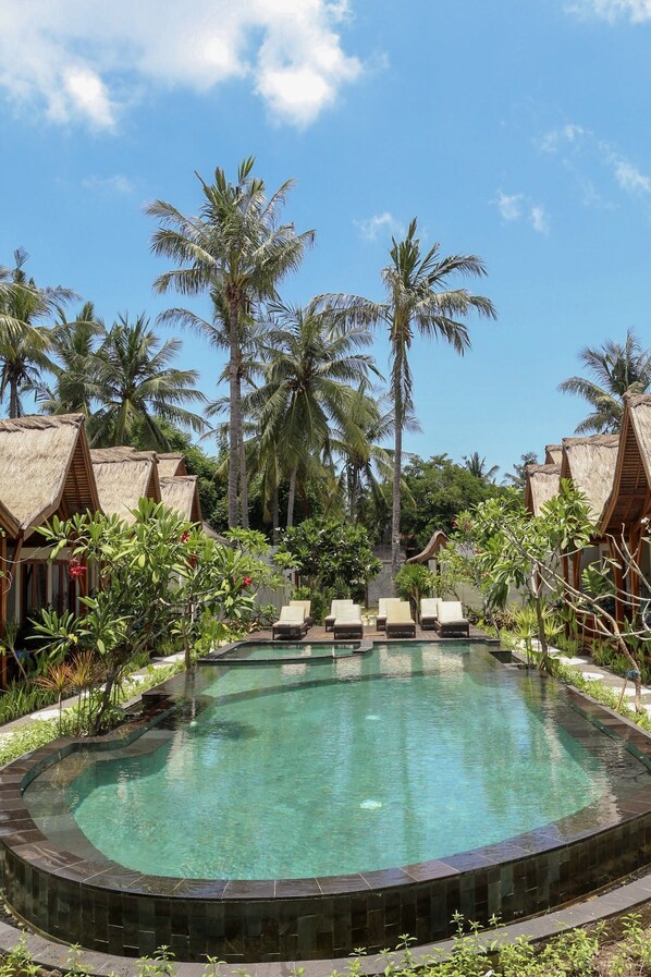 Una piscina al aire libre, tumbonas