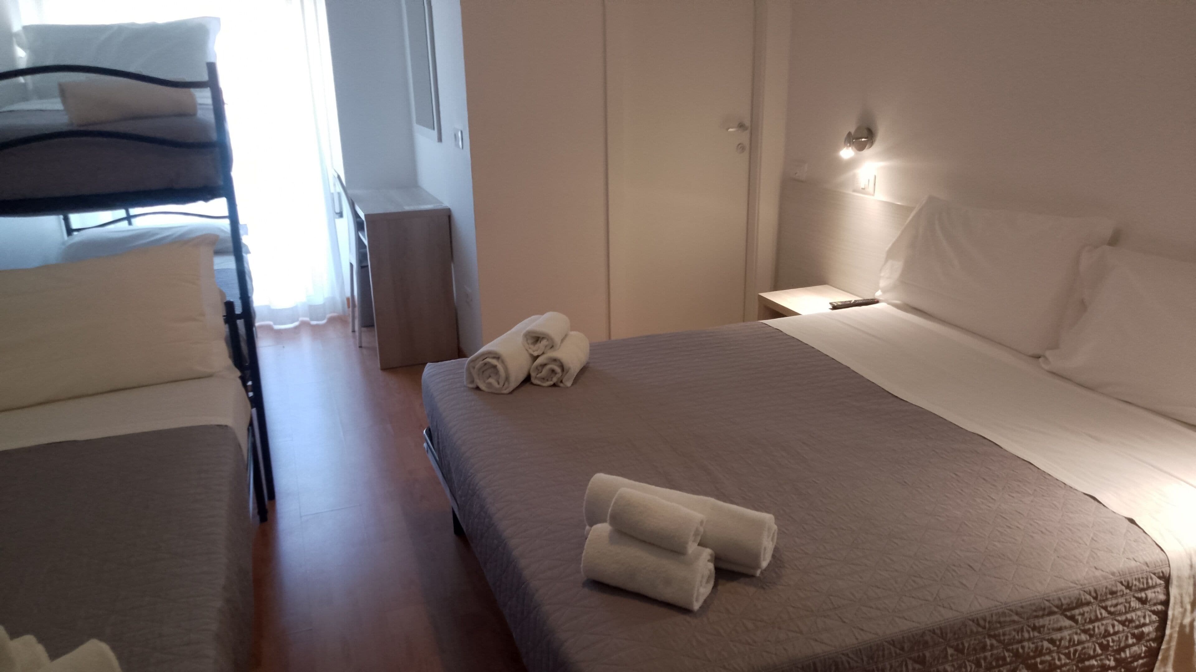 A hotel room with a bed, a chair, and a small table.