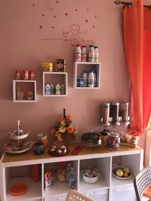 A kitchenette with various food items, a coffee machine, and storage shelves. - Il Piccolo Principe (Isernia)