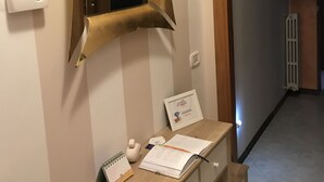 Une pièce comprenant un bureau, un miroir, un radiateur et une porte donnant sur une autre pièce.