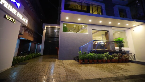 Entrada de hotel com design moderno, incluindo uma escadaria e plantas em vasos.