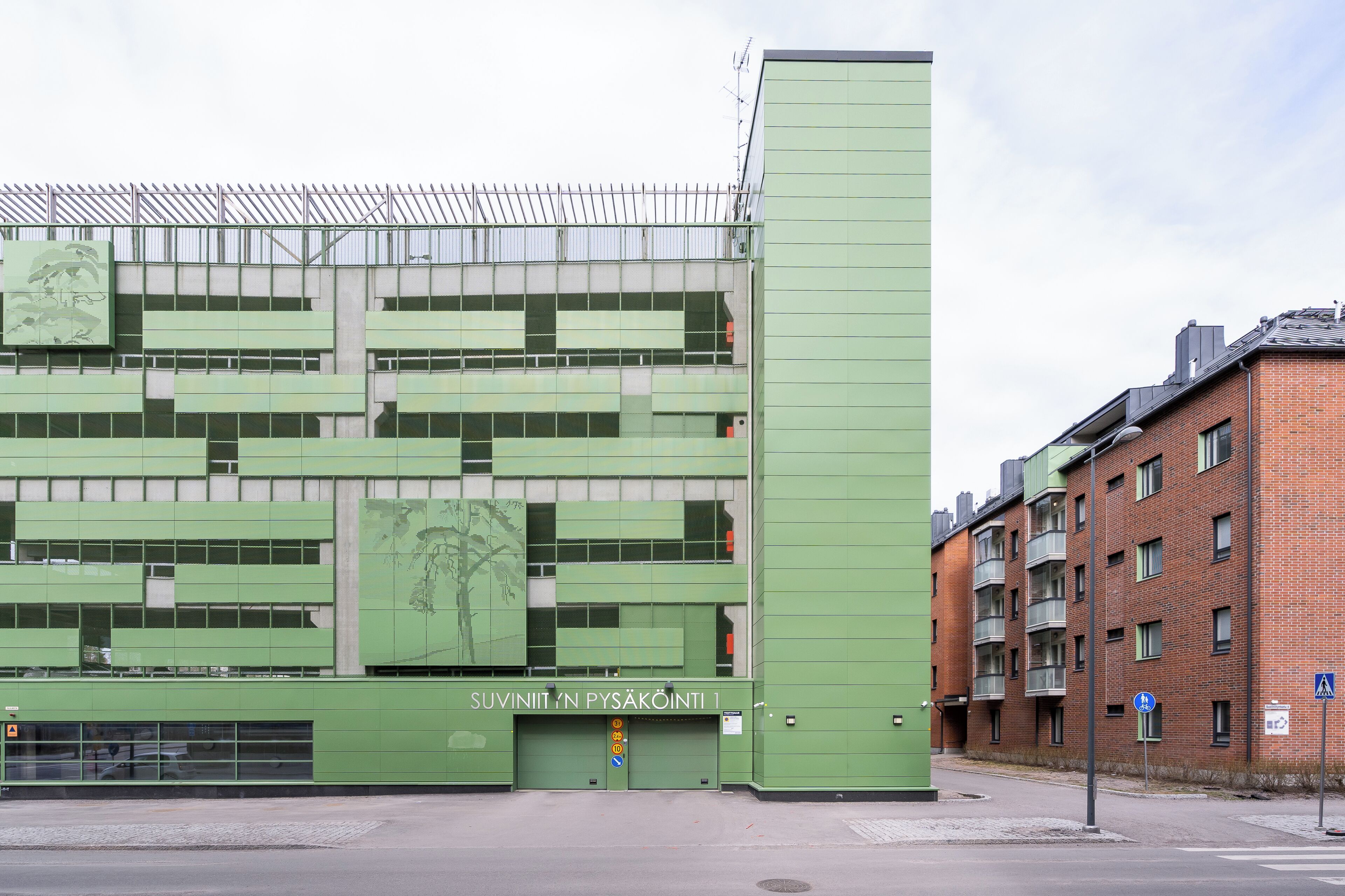 A building with a green facade, multiple floors, and a sign indicating it's a public facility.