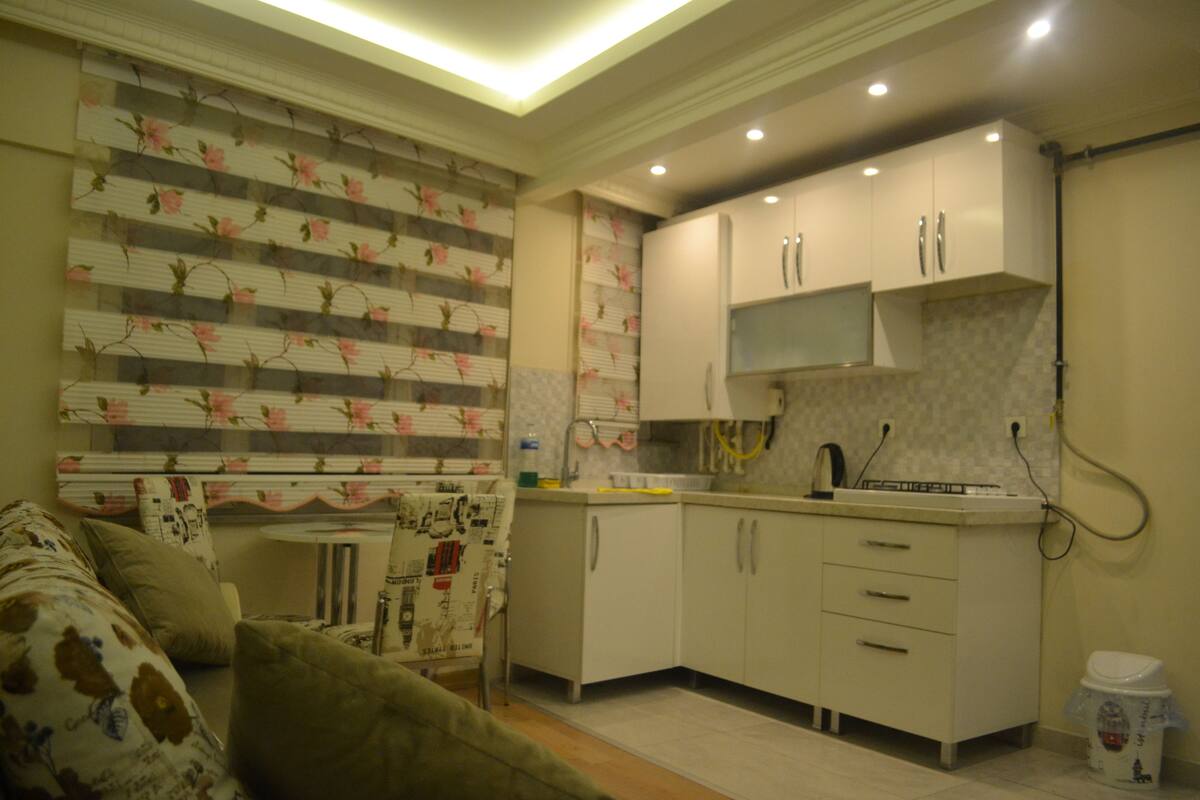A compact kitchen with white cabinets, a microwave, and a small countertop.