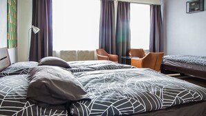 A hotel room with two beds, a desk, and two chairs. - Hotel & Bistro 63 (Poprad)