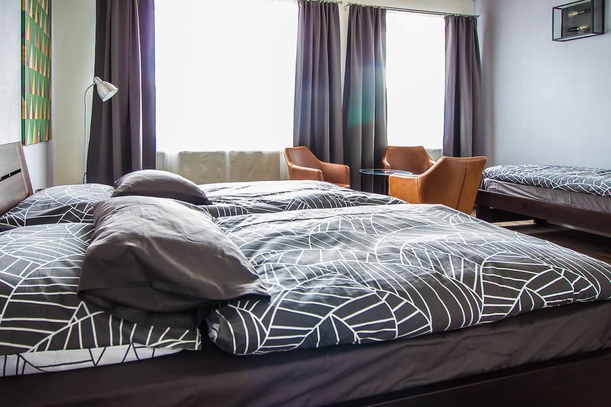 Una habitación de hotel con dos camas, un escritorio y dos sillas.