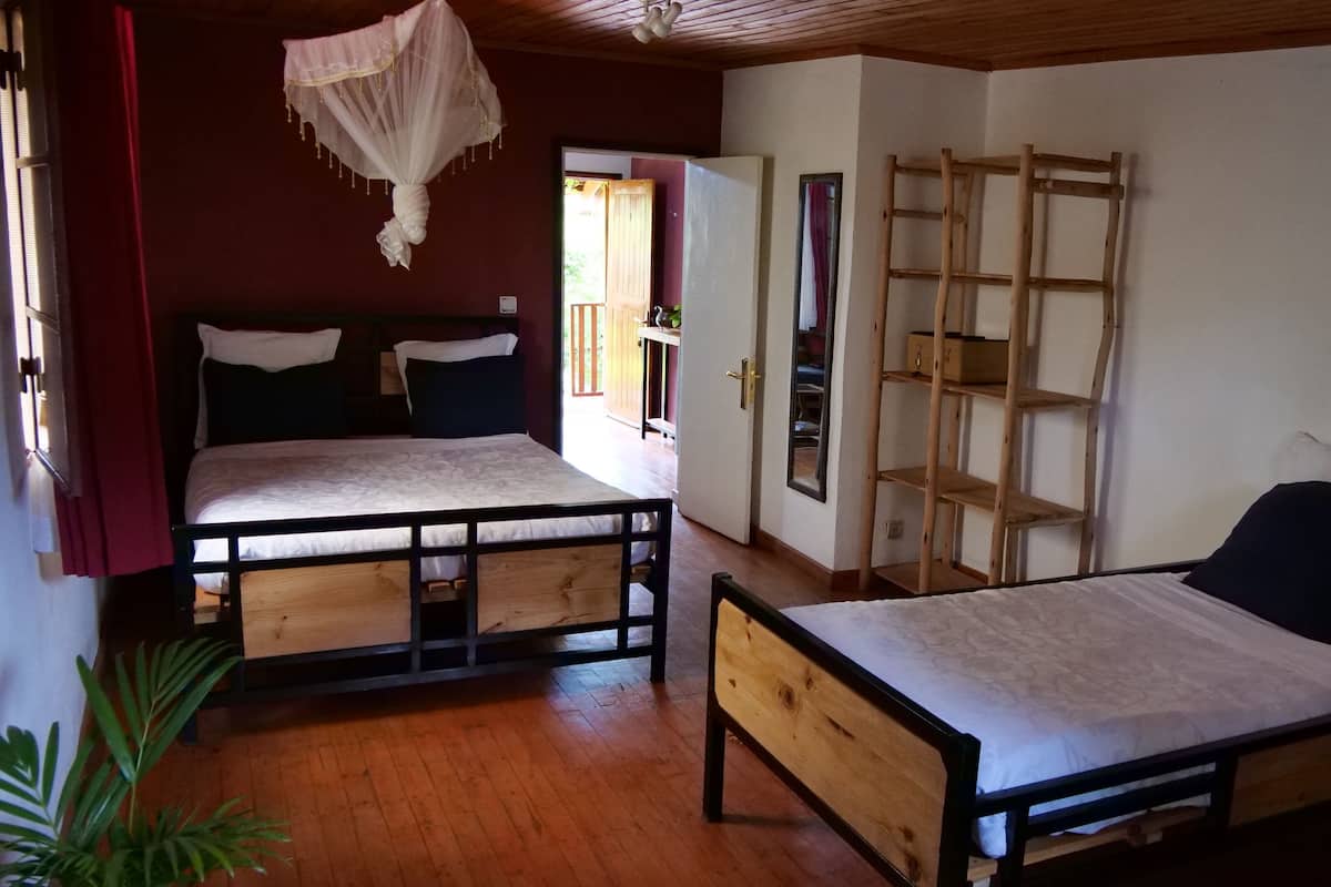 Una habitación con dos camas de madera, una escalera de madera y un espejo grande.