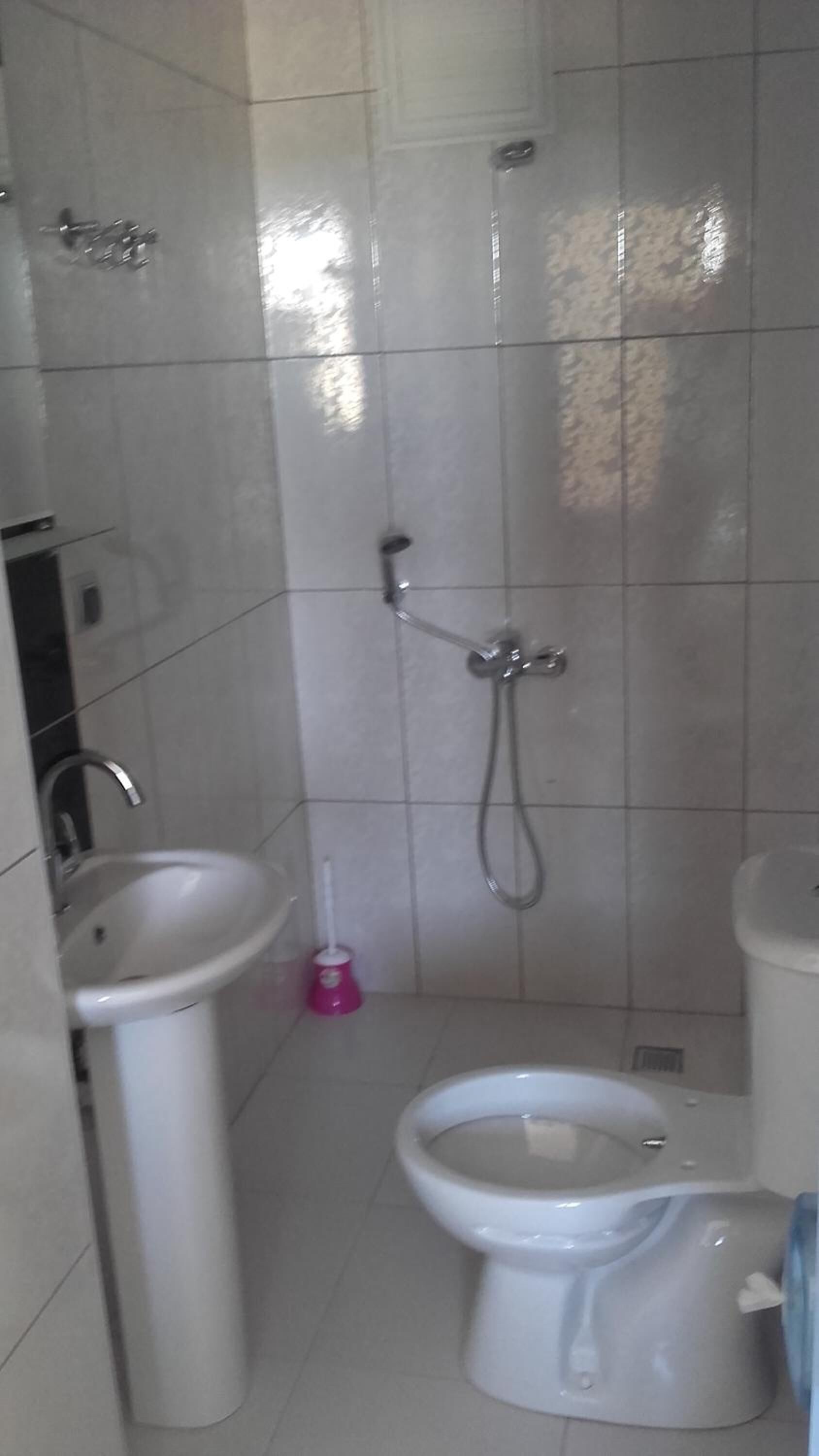 Un baño con inodoro, lavamanos y ducha.