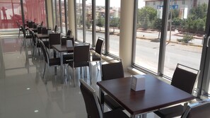 A modern indoor dining area with glass partitions, metal chairs, and tables. - Gunes Otel (Hacibektas)