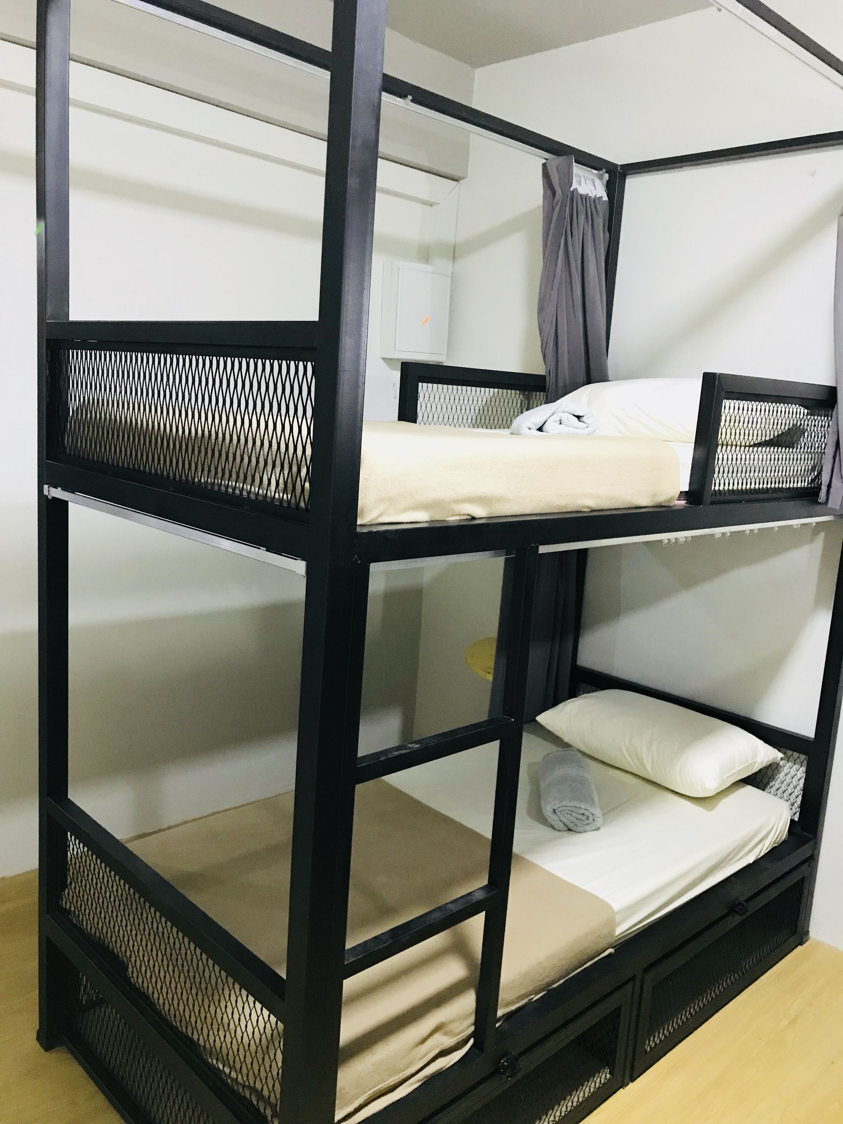 A bunk bed with a mesh headboard and a white mattress.