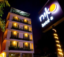 Un hotel de varios pisos con un letrero iluminado y llamativo.