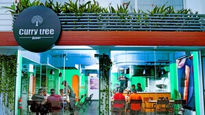 A Curry Tree Diner with a modern interior, glass partitions, and a variety of seating options. - Niko Hotels (Kanayannur)