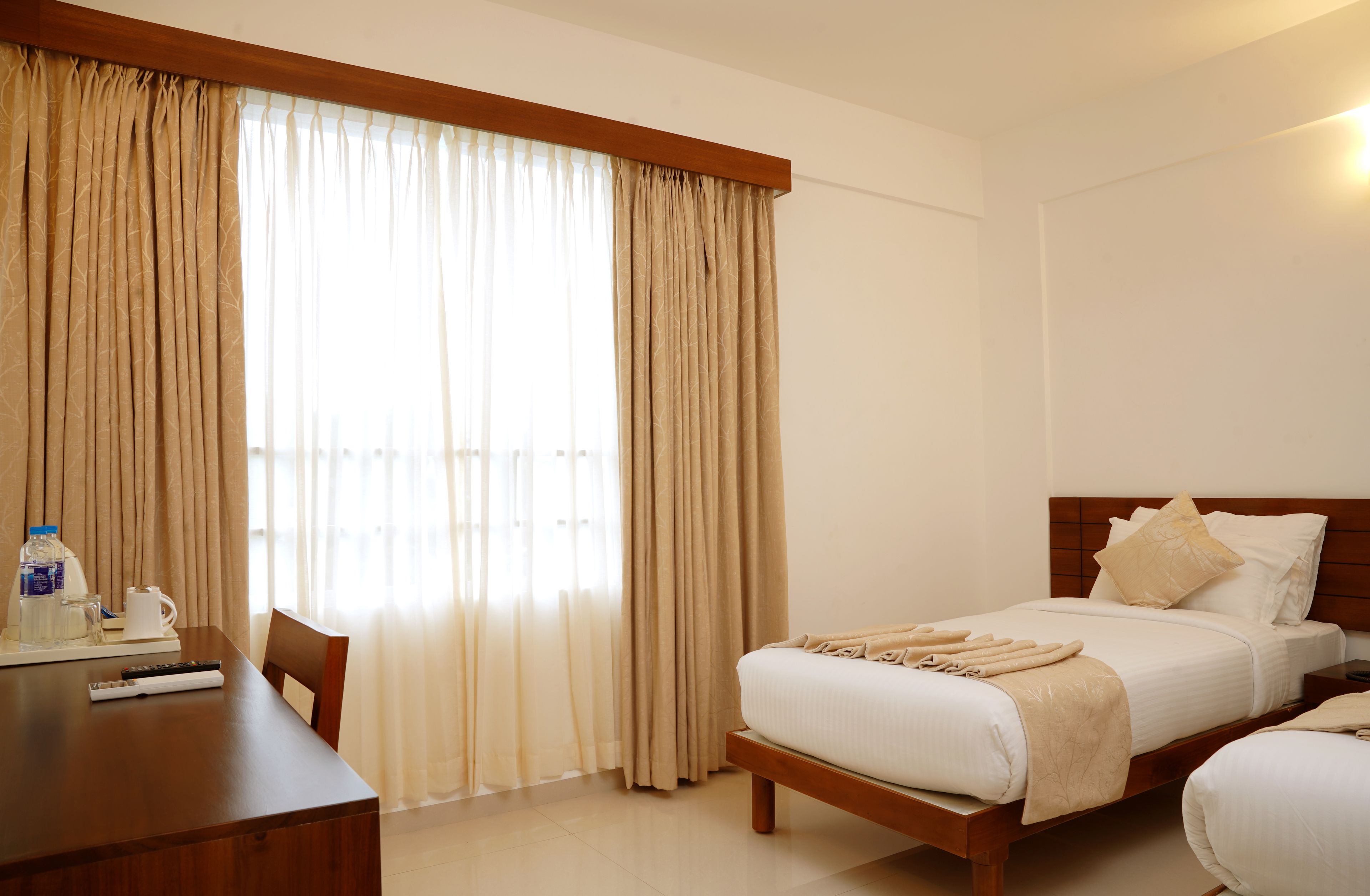 Una habitación de hotel con una cama, un escritorio y una silla.