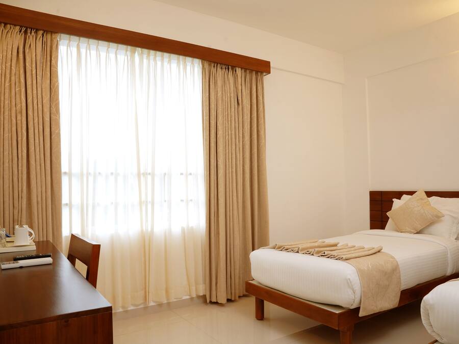 Una habitación de hotel con una cama, un escritorio y una silla.