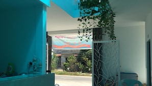 Een modern interieur met een blauwgroene accentmuur, een glazen scheidingswand en uitzicht op de straat.