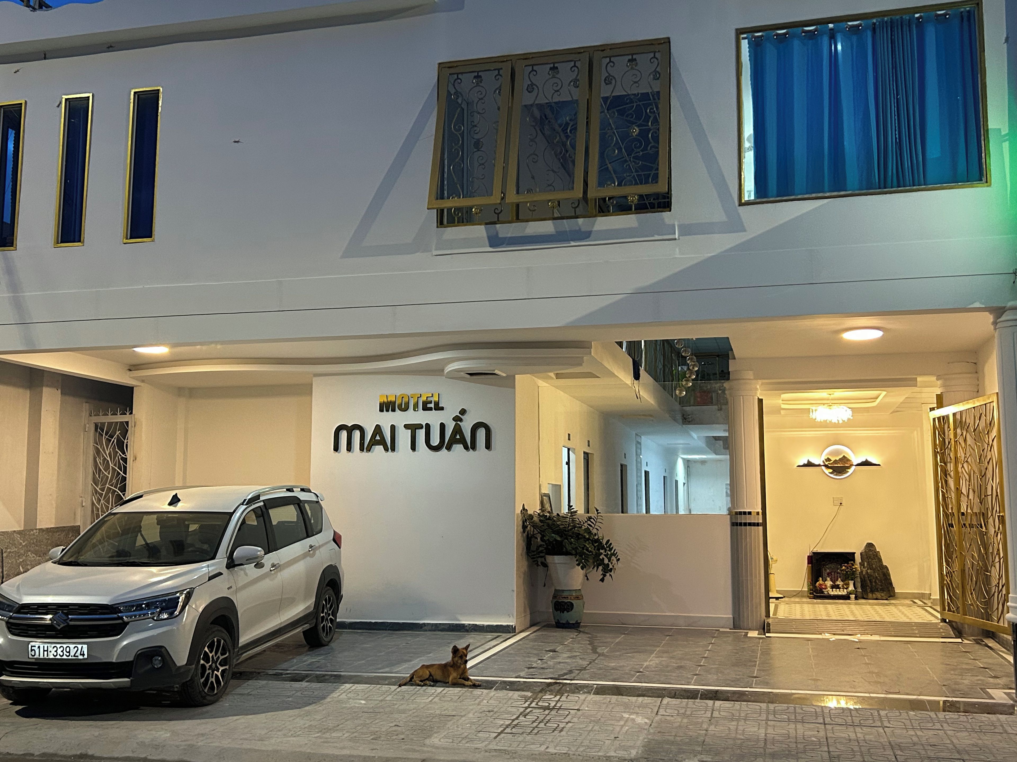Un edificio blanco con un cartel que dice 'Motel Maituán' y un coche estacionado.
