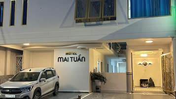 Un edificio blanco con un cartel que dice 'Motel Maituán' y un coche estacionado.