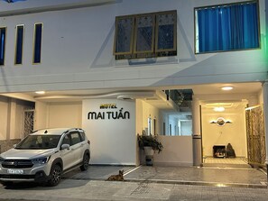 Un edifici blanc amb un rètol que diu 'Motel Maituán' i una cotxe aparcat.