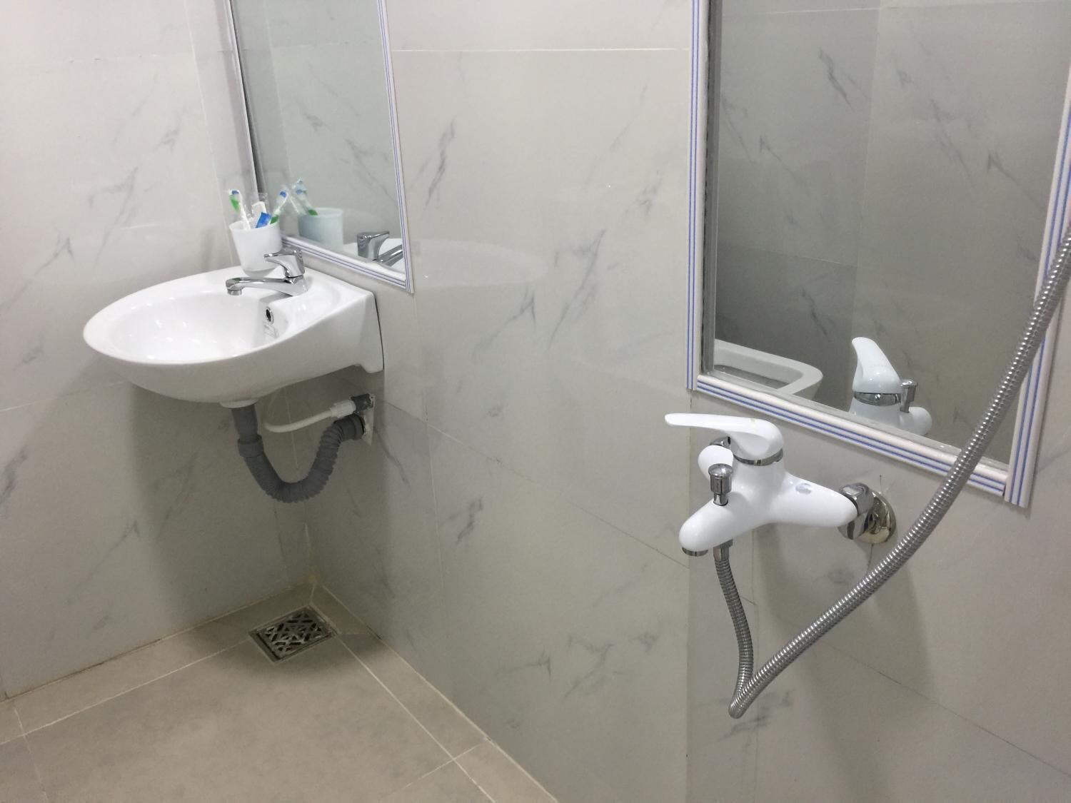 A bathroom with a white sink, a mirror, and a shower.