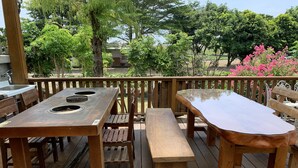 An outdoor wooden deck with a barbecue grill, picnic table, and benches. - Bo Jue Farm Stay (Ji'an)