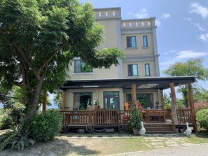 A two-story building with a covered porch and a large tree in front. - Bo Jue Farm Stay (Ji'an)