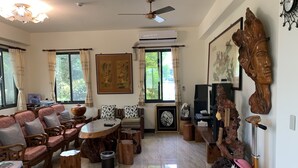 A spacious living room with a large sofa set, a dining table, and a ceiling fan. - Bo Jue Farm Stay (Ji'an)