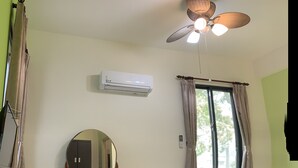 A bedroom with a bed, a desk with a chair, a ceiling fan, an air conditioner, and a window with curtains. - Bo Jue Farm Stay (Ji'an)