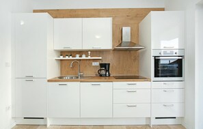 Fridge, stovetop, dishwasher, coffee/tea maker