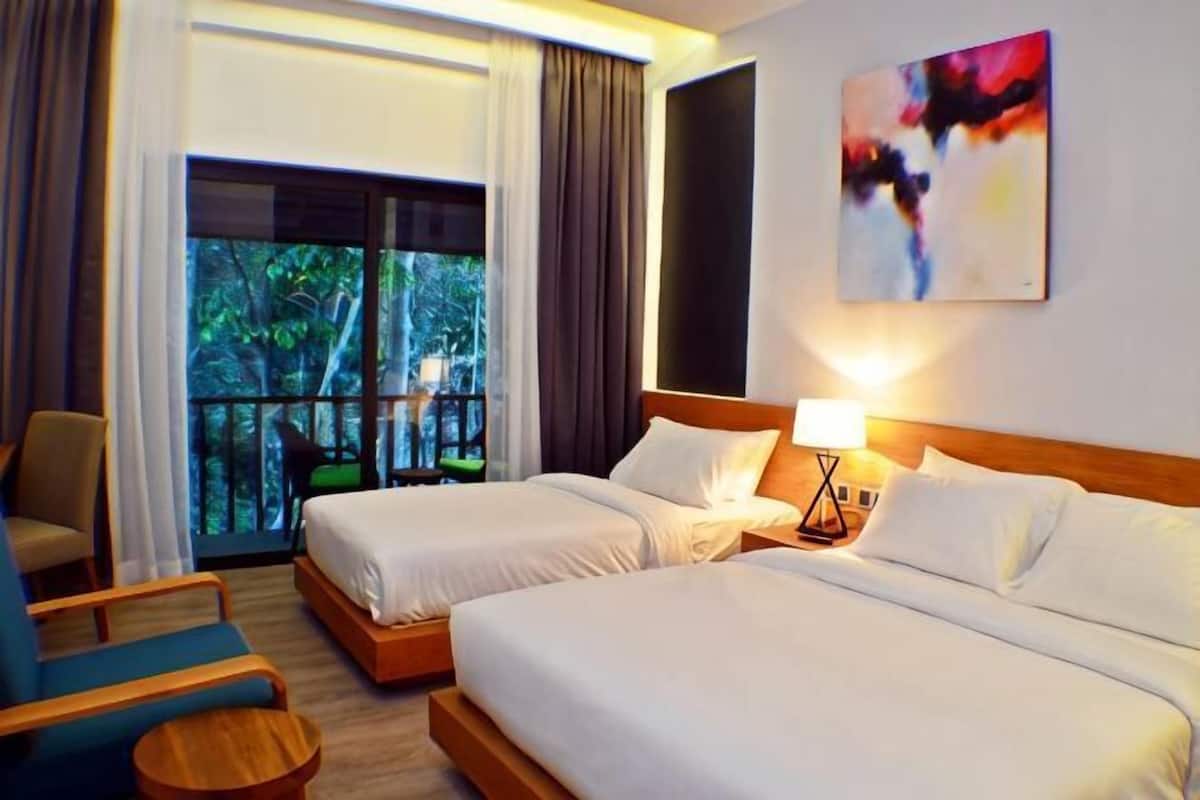 A hotel room with two beds, a balcony, a chair, and a painting on the wall.