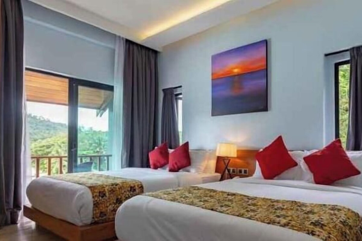 A hotel room with two beds, a painting, and a view of the outdoors.