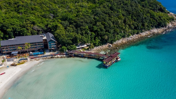 An aerial view of a resort with a beach, a pier, and lush greenery. - Mimpi Perhentian (Pulau Perhentian Kecil)