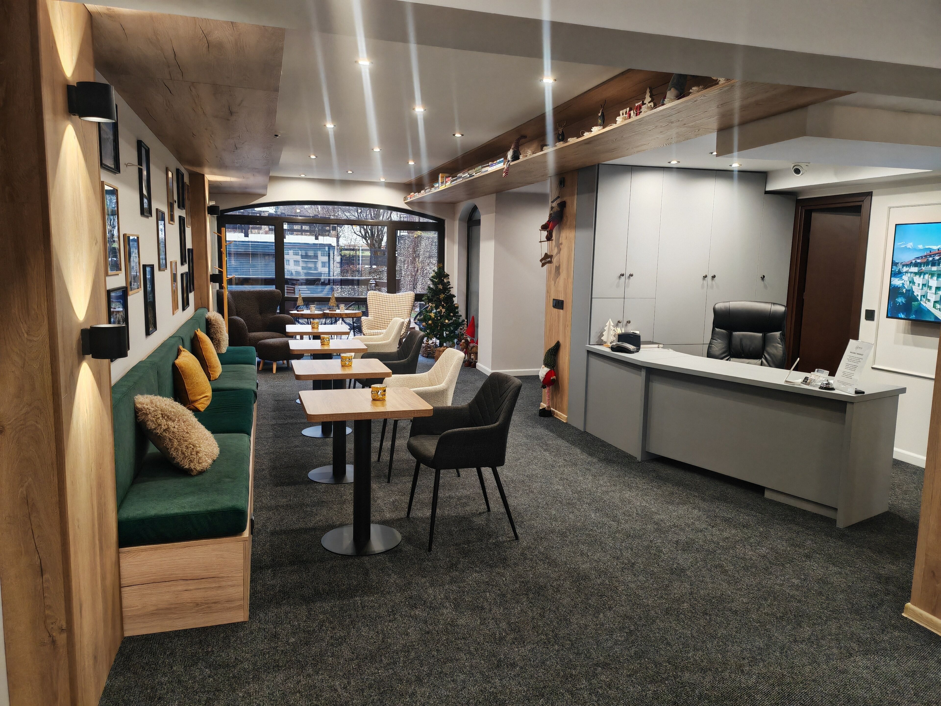 A modern interior with a green sofa, wooden accents, a Christmas tree, and a reception desk.