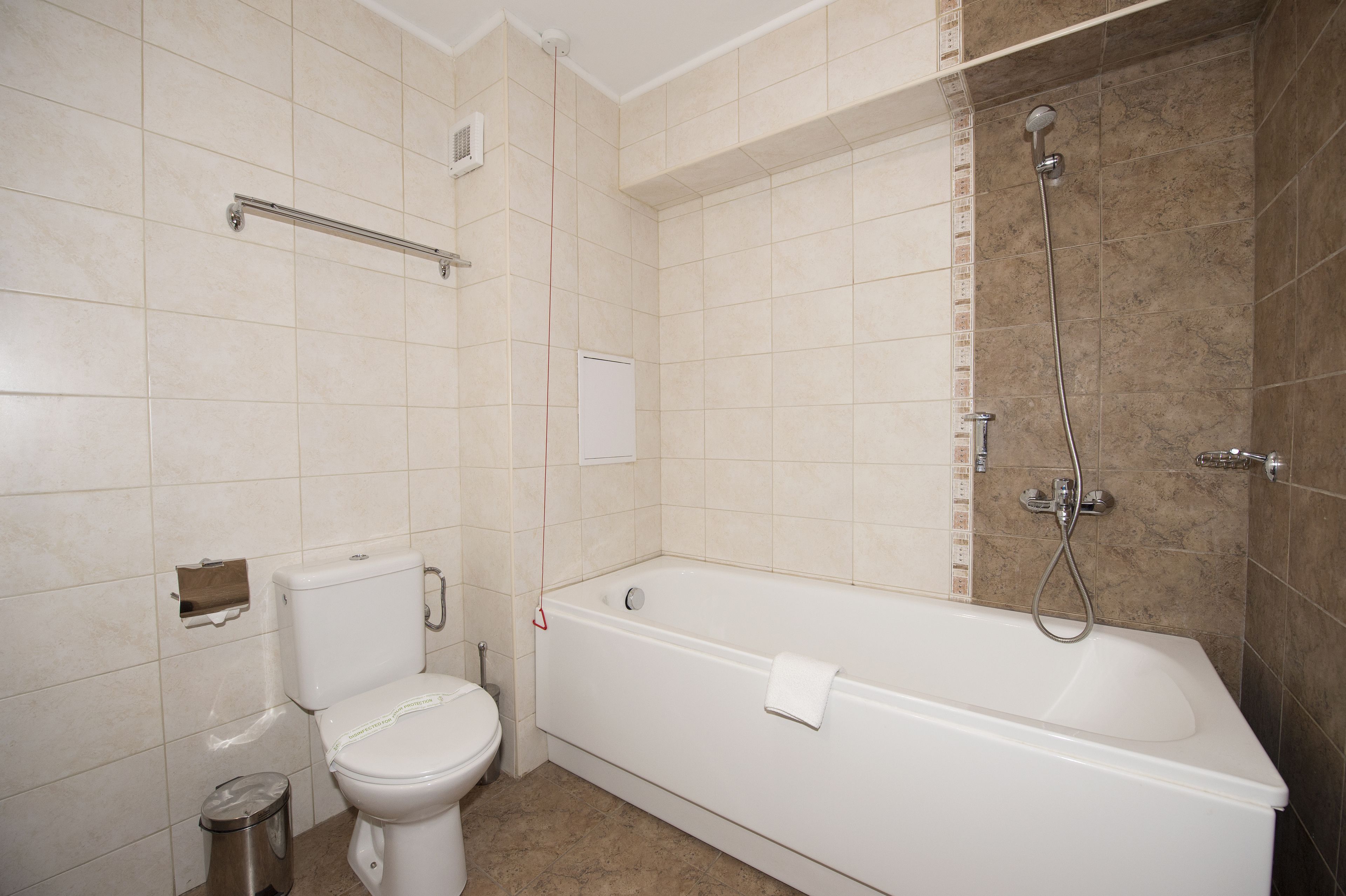 A bathroom with a toilet, a bathtub, and a shower.