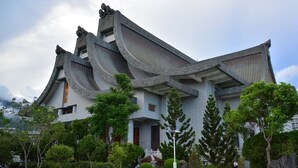 A traditional building with curved roofs and a symmetrical facade, surrounded by well-maintained greenery. - Sara's House (Hualien City)