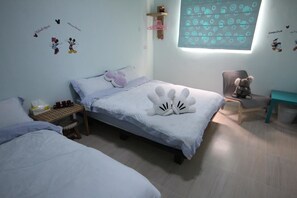 A bedroom with a bed, a small table with cups, a chair, and a window with a pattern. - Sara's House (Hualien City)