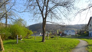 A grassy park area with a swing set and a path leading to a building. - Mosel - Bernkastel-Kues - Holiday House "Half-timbered house with charm"  (Bernkastel-Kues)