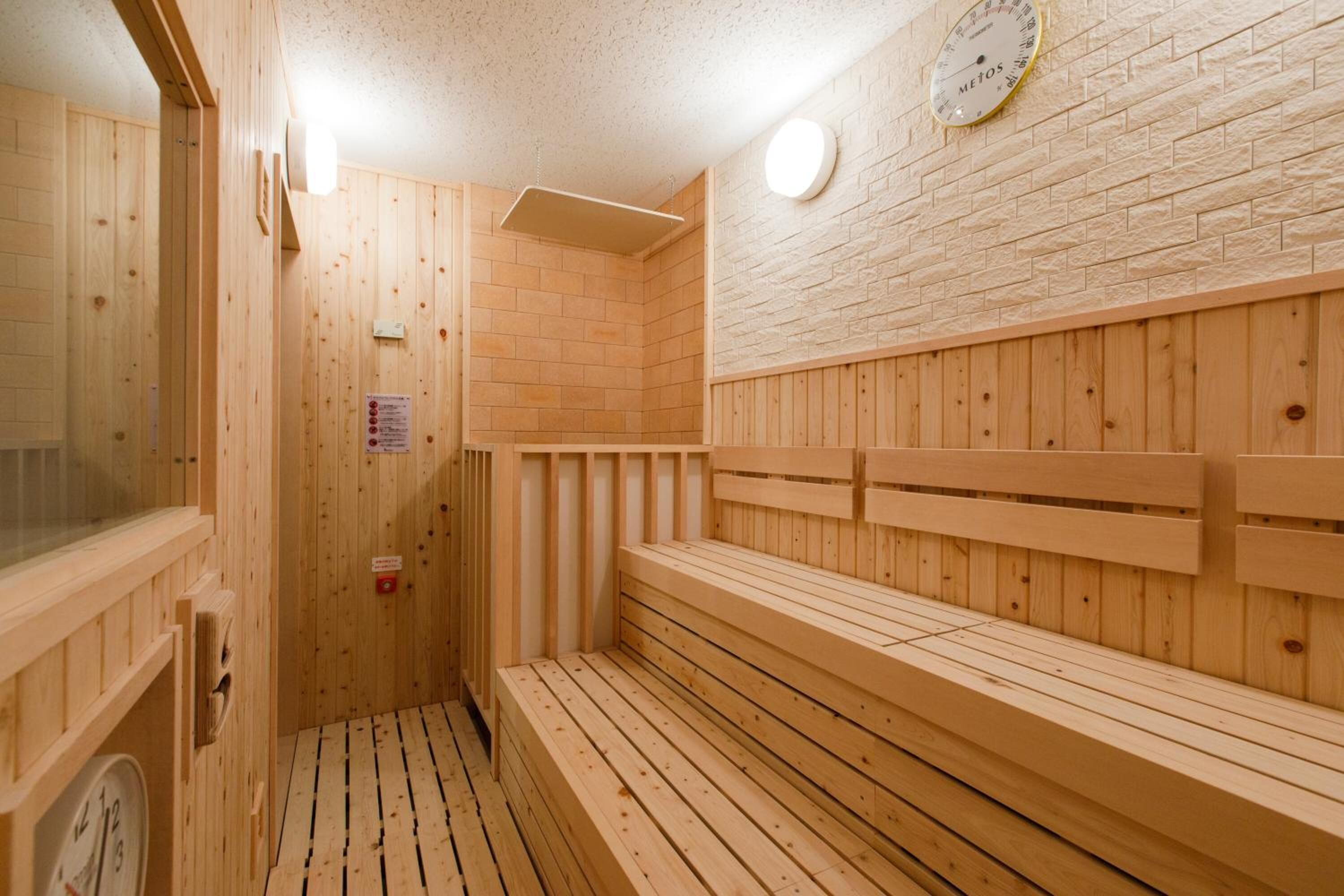 A wooden sauna with benches and a clock on the wall.