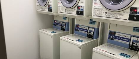 A row of front-loading washing machines with control panels, each with a price tag.