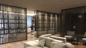 A modern living room with a sectional sofa, a coffee table, and a TV in the background. - New Tomakomai Prince Hotel Nagomi (Tomakomai)