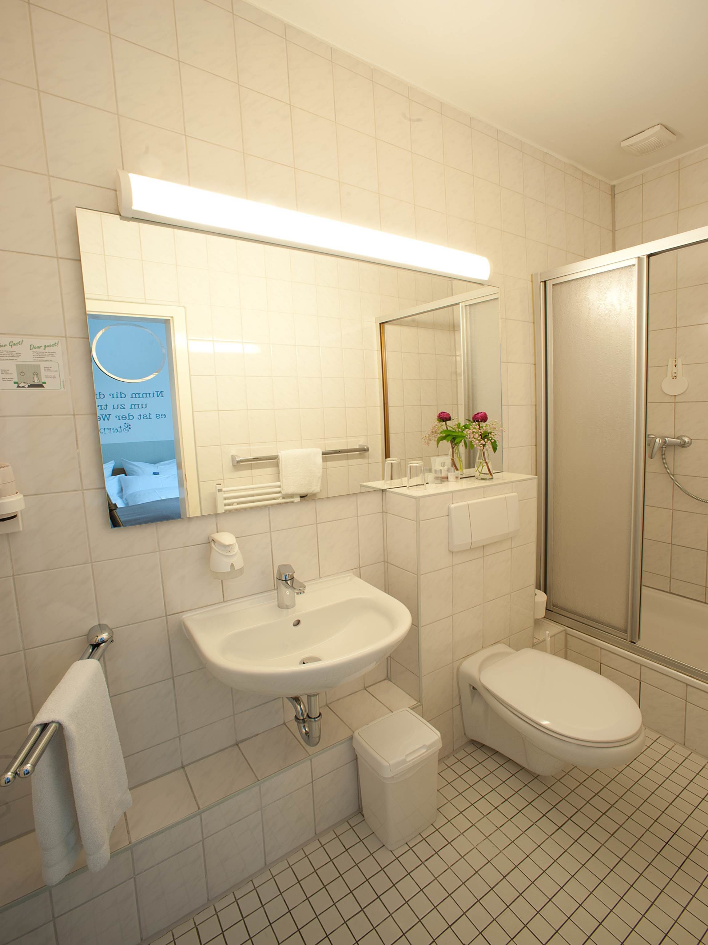 Ein modernes Badezimmer mit Waschbecken, Toilette und Dusche.