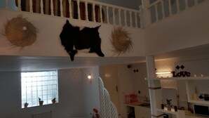 Interior de varios niveles con una escalera, una cabeza de animal montada en la pared y un cartel que dice 'Love'.