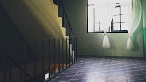 A staircase leading to a landing with a view of a building outside.