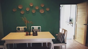 A dining area with a table, chairs, and decorative wall hangings.