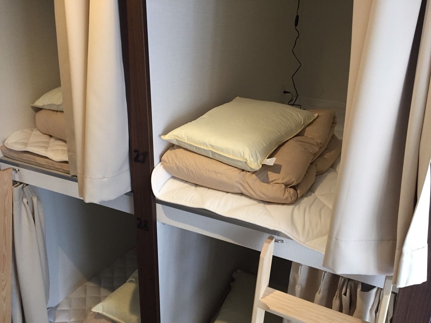 Une chambre de type dortoir avec des lits superposés, chaque lit étant équipé d’un matelas et d’oreillers.